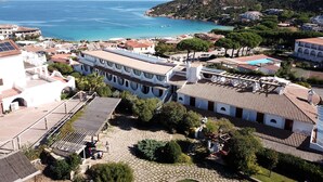Eine Küstenstadt mit Häusern mit Terrakotta-Dächern, einem gepflasterten Platz und Blick auf das Meer.