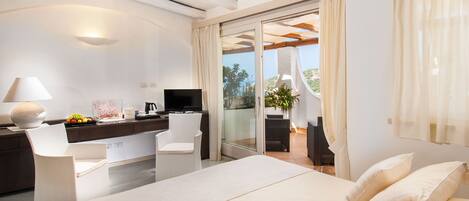 A modern bedroom with a large bed, a desk, and a TV.