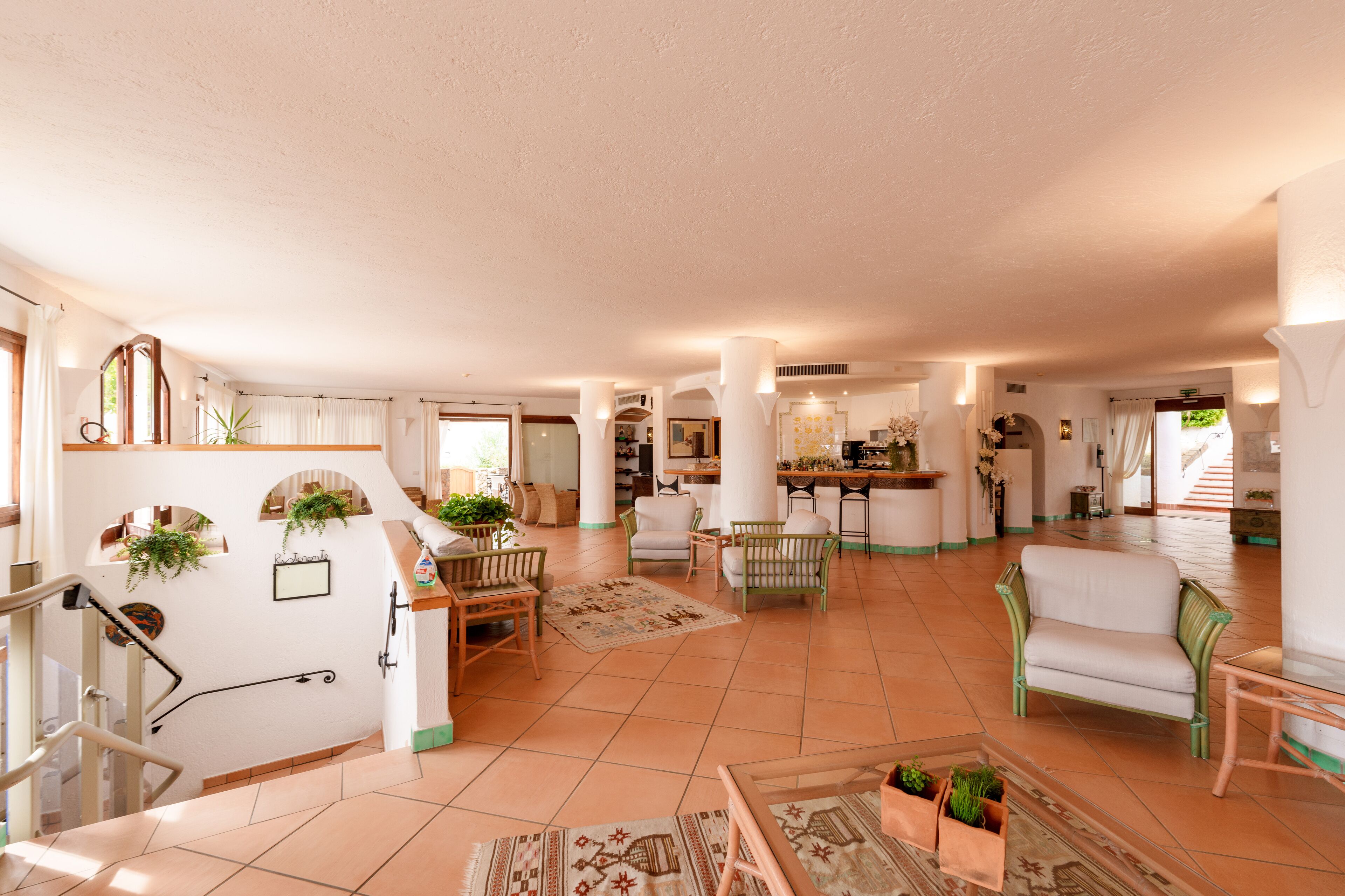 A spacious living area with a kitchen, dining area, and a staircase leading to another level.