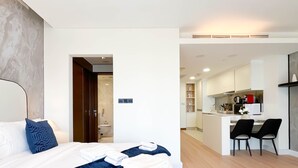 A modern hotel room with a bed, a desk, and a kitchenette. - Luxury residence at Fashion Avenue Dubai Mall (Dubai)