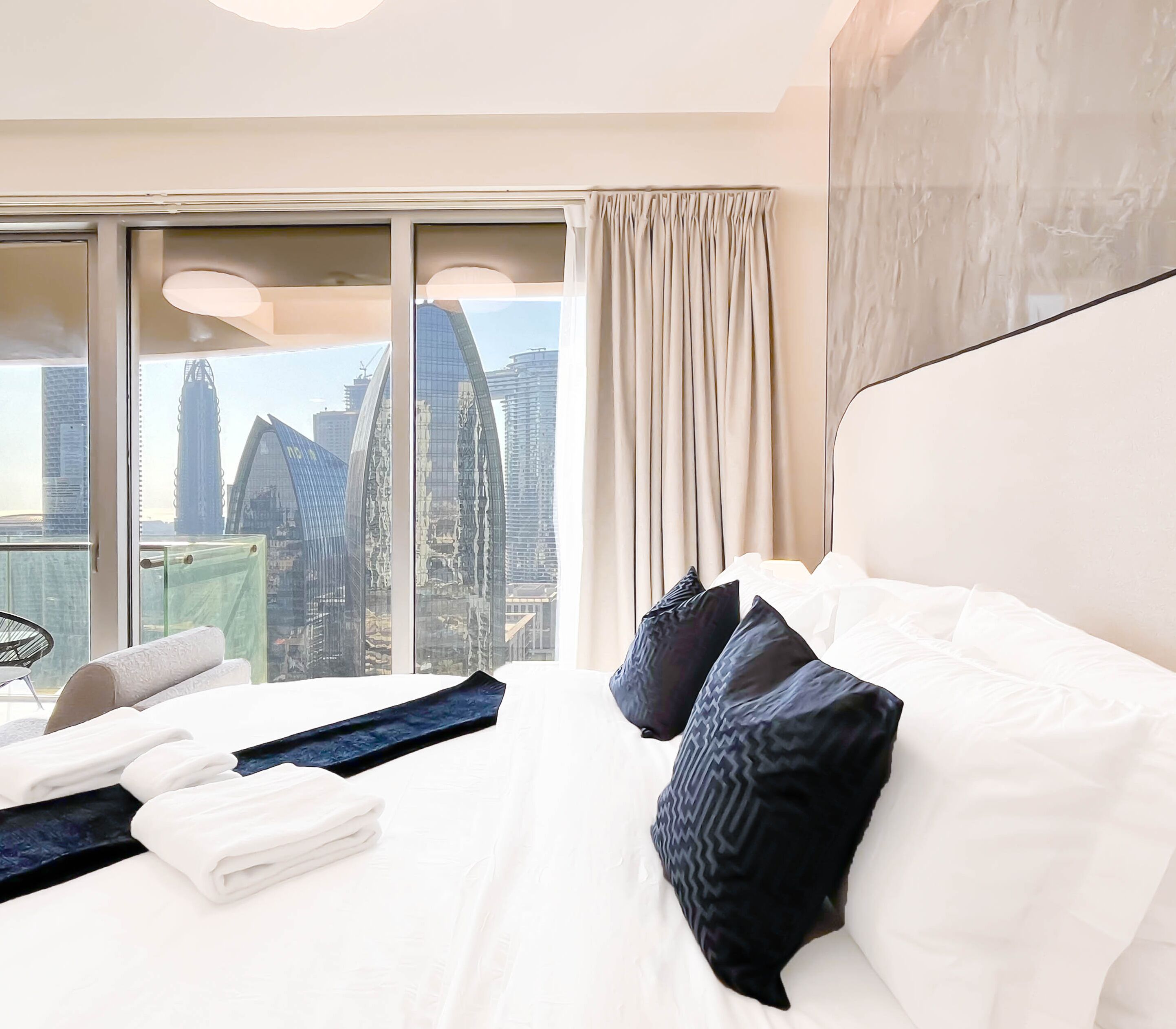 Une chambre d’hôtel dotée d’un grand lit, offrant une vue sur les bâtiments de la ville et présentant un design moderne.