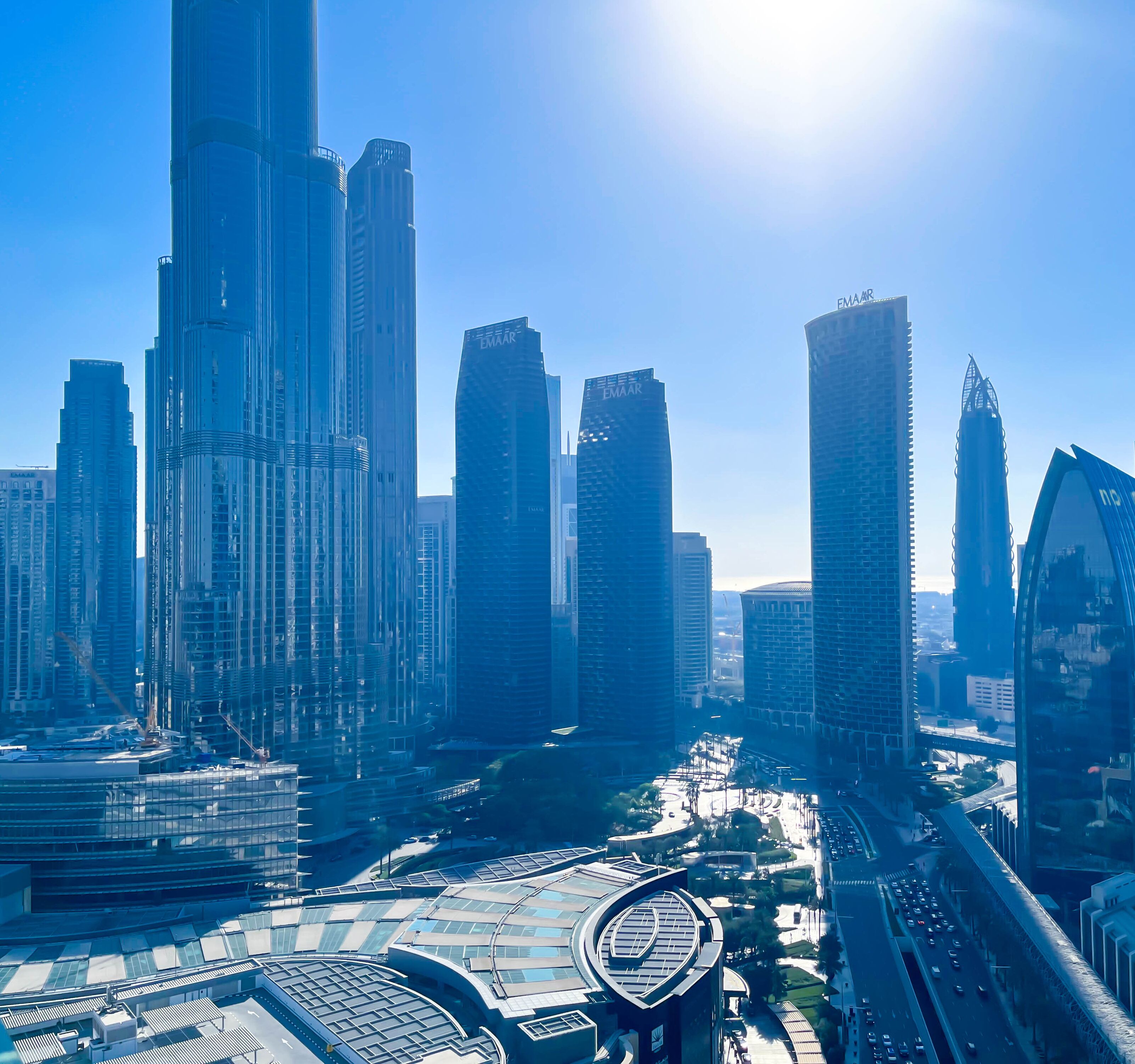 Paisagem urbana moderna com edifícios altos, incluindo um arranha-céu imponente com design curvo.