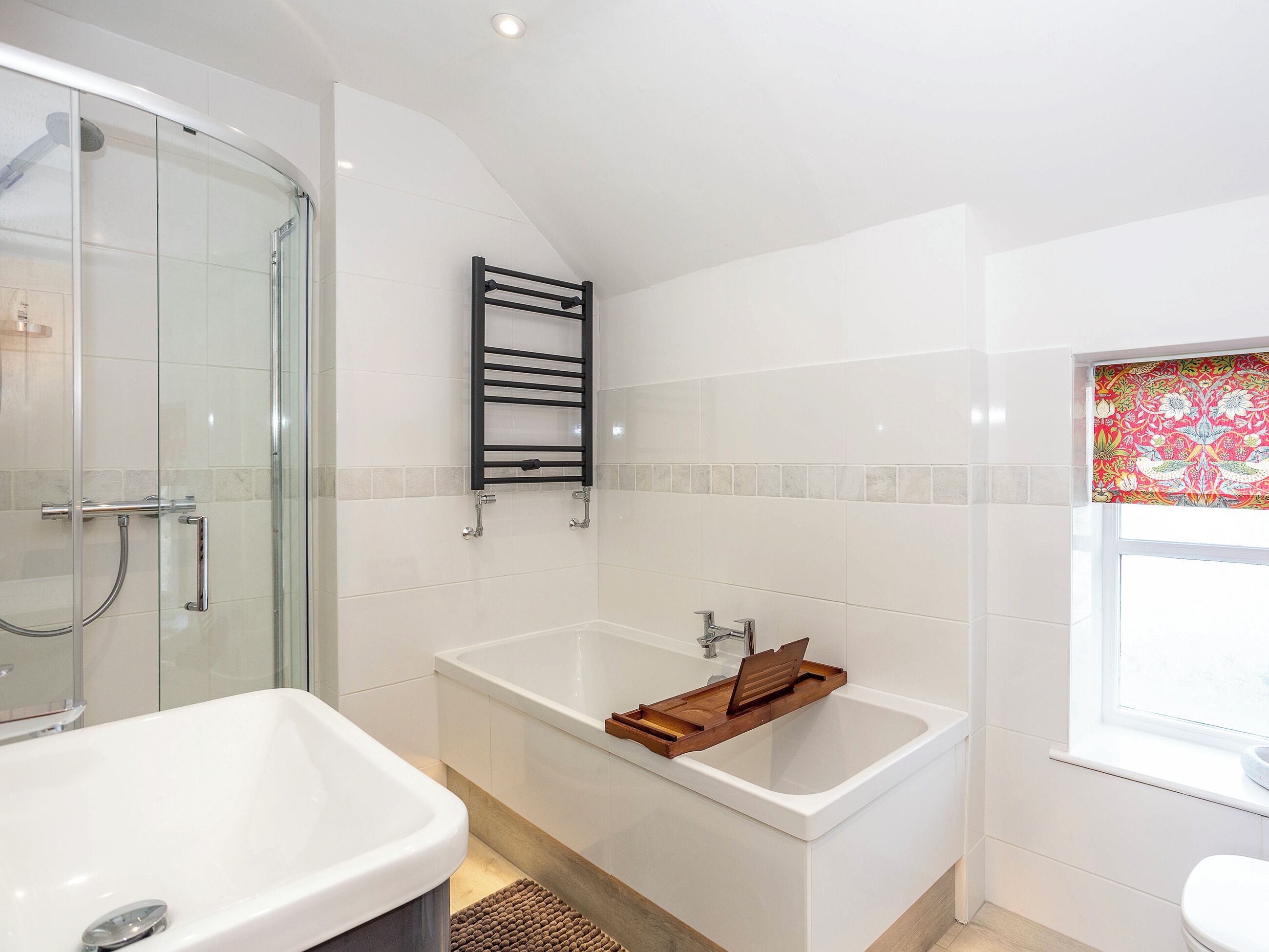 A modern bathroom with a glass shower enclosure, a freestanding bathtub, and a toilet.