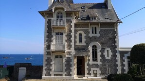 Ein Steinhaus mit Balkon und Meerblick.
