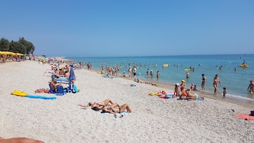 Plage privée, sable noir, chaises longues, parasols