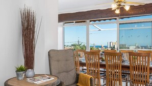 A dining area with a view of the city, a ceiling fan, and a table with chairs. - Villa Suenios - PlusHolidays (Calpe)