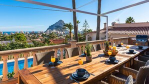 A rooftop dining area with a view of a cityscape and a mountain. - Villa Suenios - PlusHolidays (Calpe)