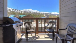 A balcony with a grill, two chairs, and a view of snow-capped mountains. - Ski in/Ski Out 100 yards, Masive Views, On Shuttle Route, Hot Tub, Fireplace (Breckenridge)