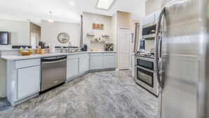 A modern kitchen with a dishwasher, oven, and stainless steel refrigerator. - By Disney Universal Pvt. Pool Sleeps 10! Game rm Free Bbq, Parking,WiFi, Fishing (Kissimmee)