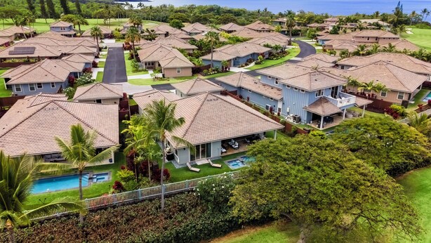 A residential area with houses, a swimming pool, and a view of the ocean. - Holua Kai #27: Luxury Oceanfront Villa w/Private and Resort Pools & Spas (Kailua Kona)