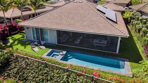 A modern house with a swimming pool, surrounded by lush greenery and palm trees. - Holua Kai #27: Luxury Oceanfront Villa w/Private and Resort Pools & Spas (Kailua Kona)