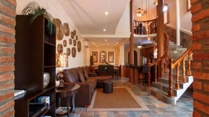 A spacious living area with a fireplace, a staircase, and a dining area.