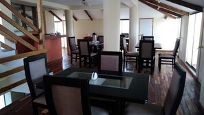 A dining area with wooden beams, a staircase, and a view of the outdoors. - Qorikilla Hostal (Cusco)