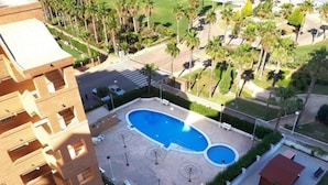 A hotel with a central swimming pool, palm trees, and a parking area. - Oropesa Ciudad de Vacaciones 3000 (Oropesa del Mar)