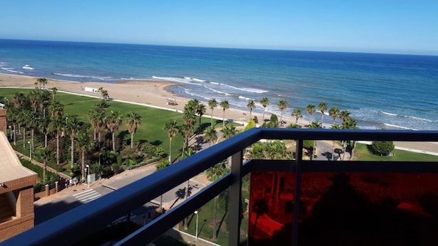 A view of a beach with palm trees and a clear blue sky. - Oropesa Ciudad de Vacaciones 3000 (Oropesa del Mar)