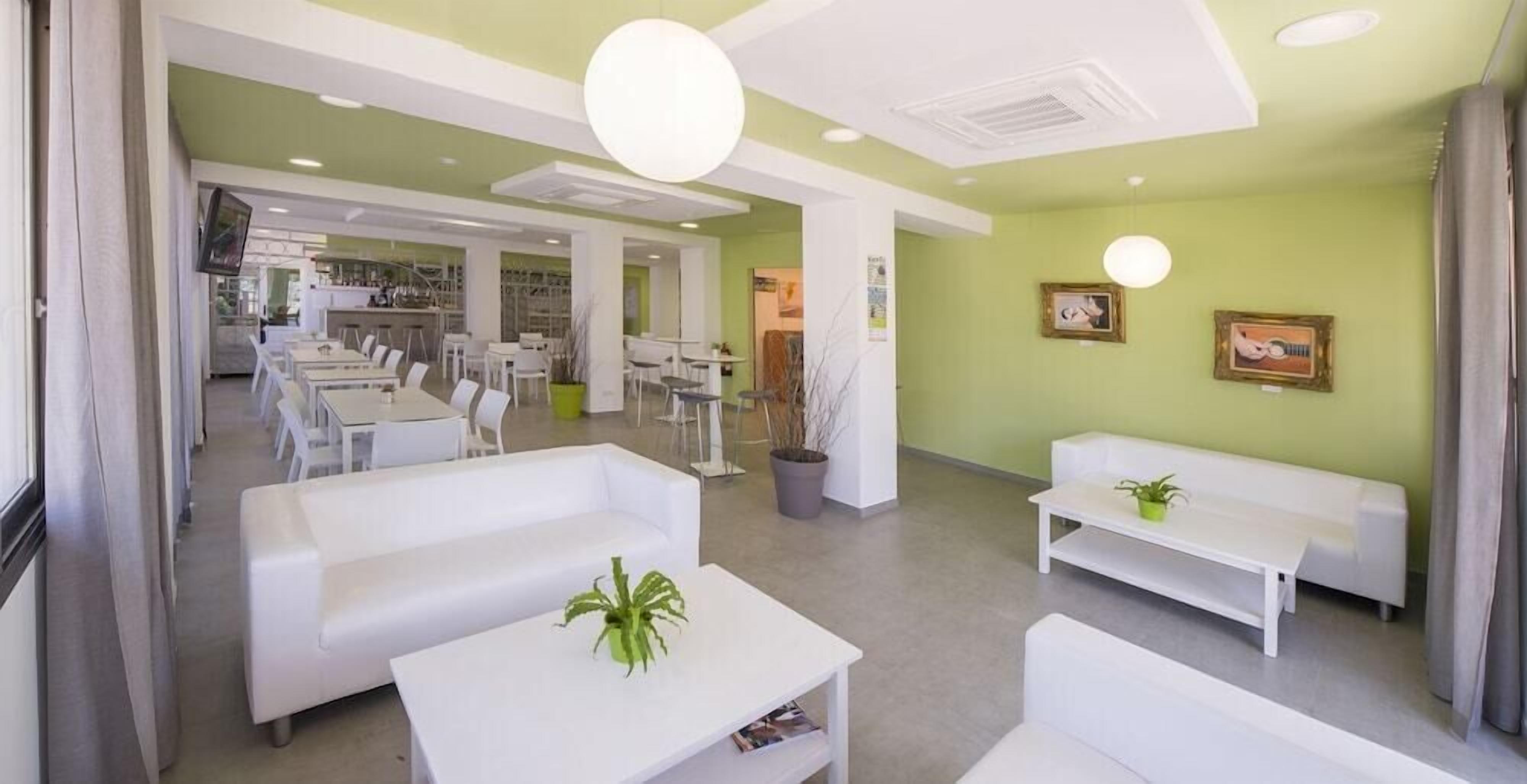 Een modern interieur met witte meubels, een receptie en een eetruimte.
