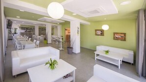 A modern interior with white furniture, a reception area, and a dining space. - Hotel Bahia Playa (Sant Josep de sa Talaia)