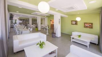 Een modern interieur met witte meubels, een receptie en een eetruimte.