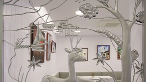 A room with a white wall, a staircase, and a large tree sculpture. - Hotel Bahia Playa (Sant Josep de sa Talaia)
