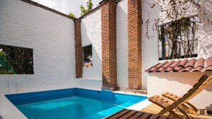 A swimming pool with a wooden deck and lounge chair. - Hotel Costa 55 (Puerto Escondido)
