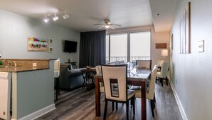 A modern living room with a dining area, a kitchen, and a balcony with a view. - Spacious 9th floor, 2 bedroom plus bunkroom with STUNNING OCEAN & POOL VIEWS! (Panama City Beach)
