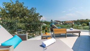 Una terraza en la azotea con sillones de descanso, una mesa y una botella de champán.