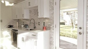 A modern kitchen with white cabinets, a stainless steel dishwasher, and a sink. - 5 bedrooms with 4 Full Bath, Fire Pit,  BBQ and Plush Amen on 1/2 acre (Silver Spring)