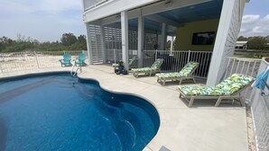 Una piscina amb gandules i una zona de pati coberta.