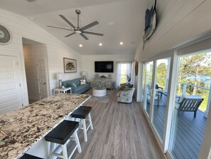 Relax in this inviting space with a large window offering a view of trees and a body of water.