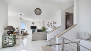 A spacious living area with a staircase, a dining area, and a kitchen.