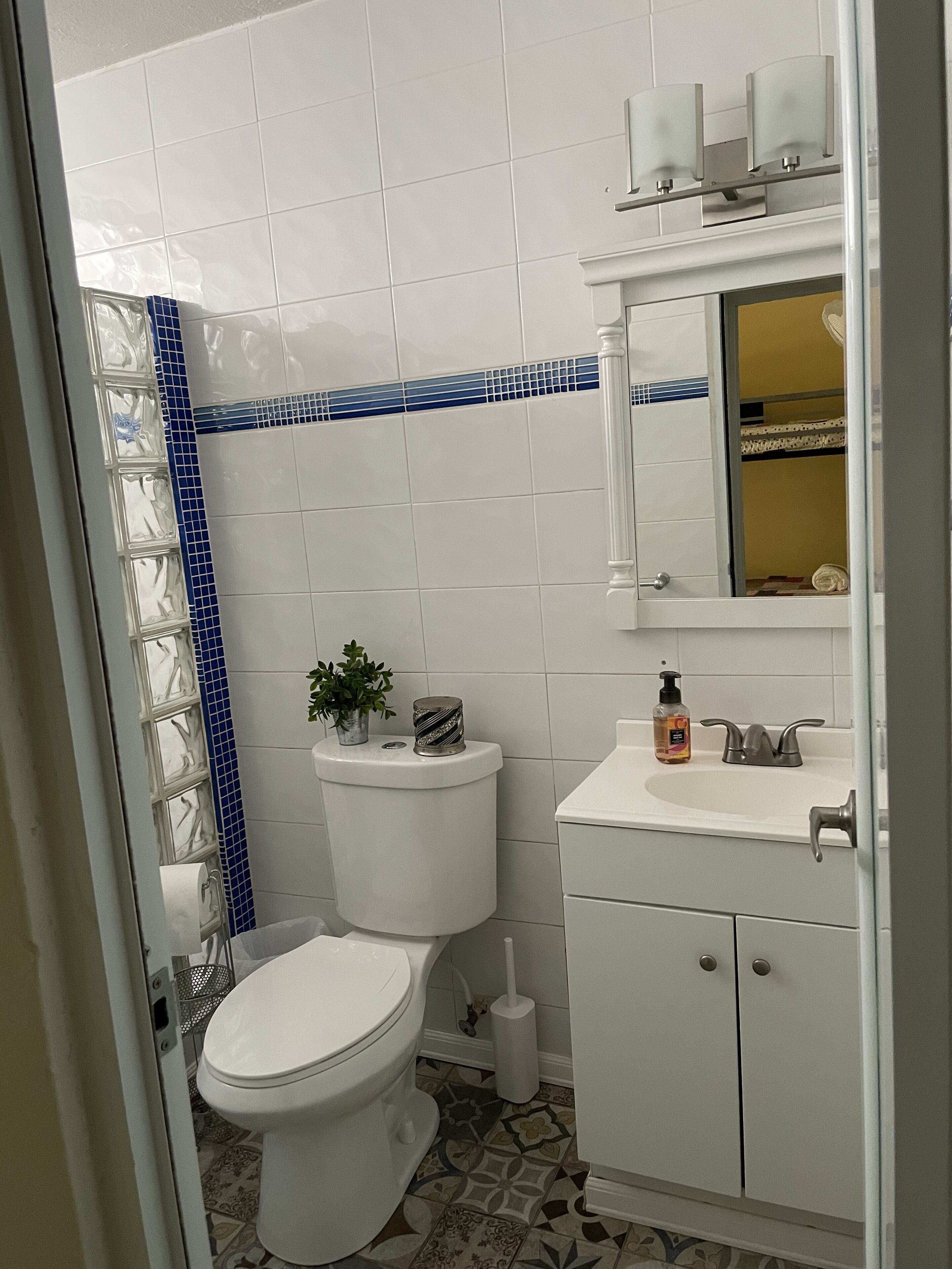 Een badkamer met toilet, wastafel en spiegel.