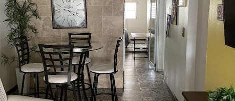 Uma sala de jantar com relógio de parede, cadeiras e mesa.
