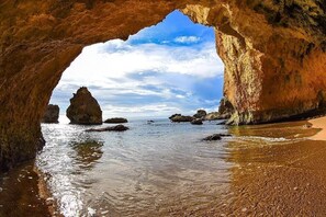 Une formation rocheuse naturelle offrant une vue dégagée sur l’océan, encadrée par une arche.