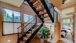 A modern interior with a spiral staircase, large windows, and a potted plant. - Old Town Loft Oasis with Amazing Rooftop Deck! (Fort Collins)