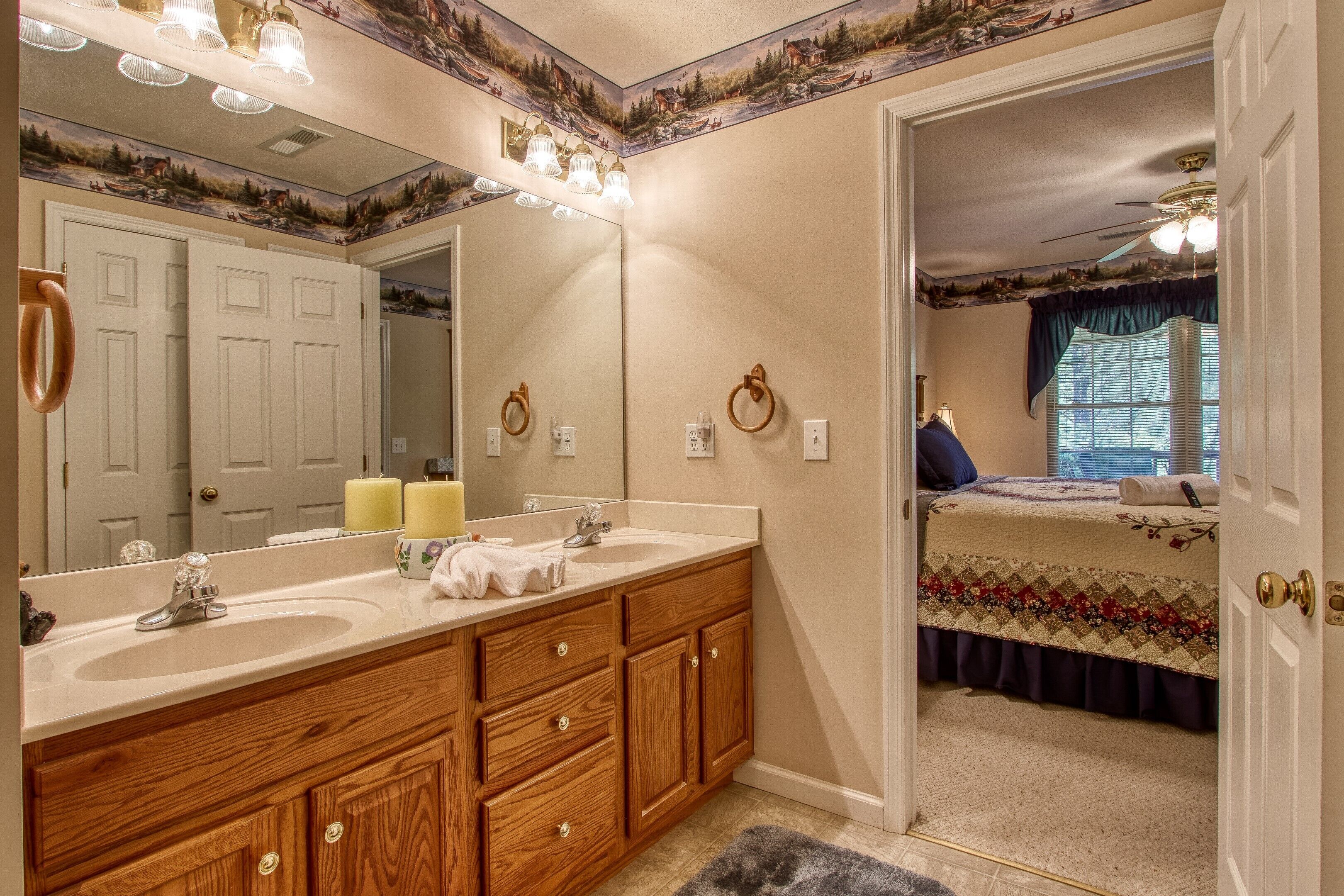 A bathroom with a double sink, wooden vanity, and a large mirror.