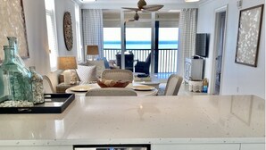 A spacious kitchen with a large island, white cabinetry, and a view of the ocean. - Ocean front , beach views - exquisite sunsets and relaxing setting. (Naples)