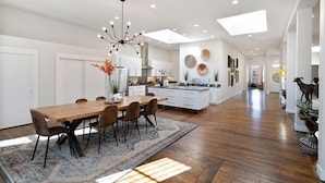 A spacious kitchen with a central island, modern pendant lighting, and a view into the dining area. - THE PENTHOUSE loft in the heart of Old Town! (Fort Collins)