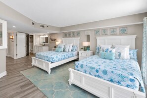 Un dormitorio con dos camas, un baño y un pasillo.