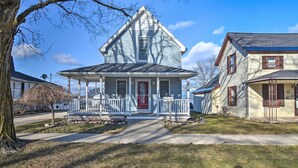 A two-story house with a front porch, a garage, and a driveway. - Downtown Boyne City Home, Walk to Lake Charlevoix! (Boyne City)