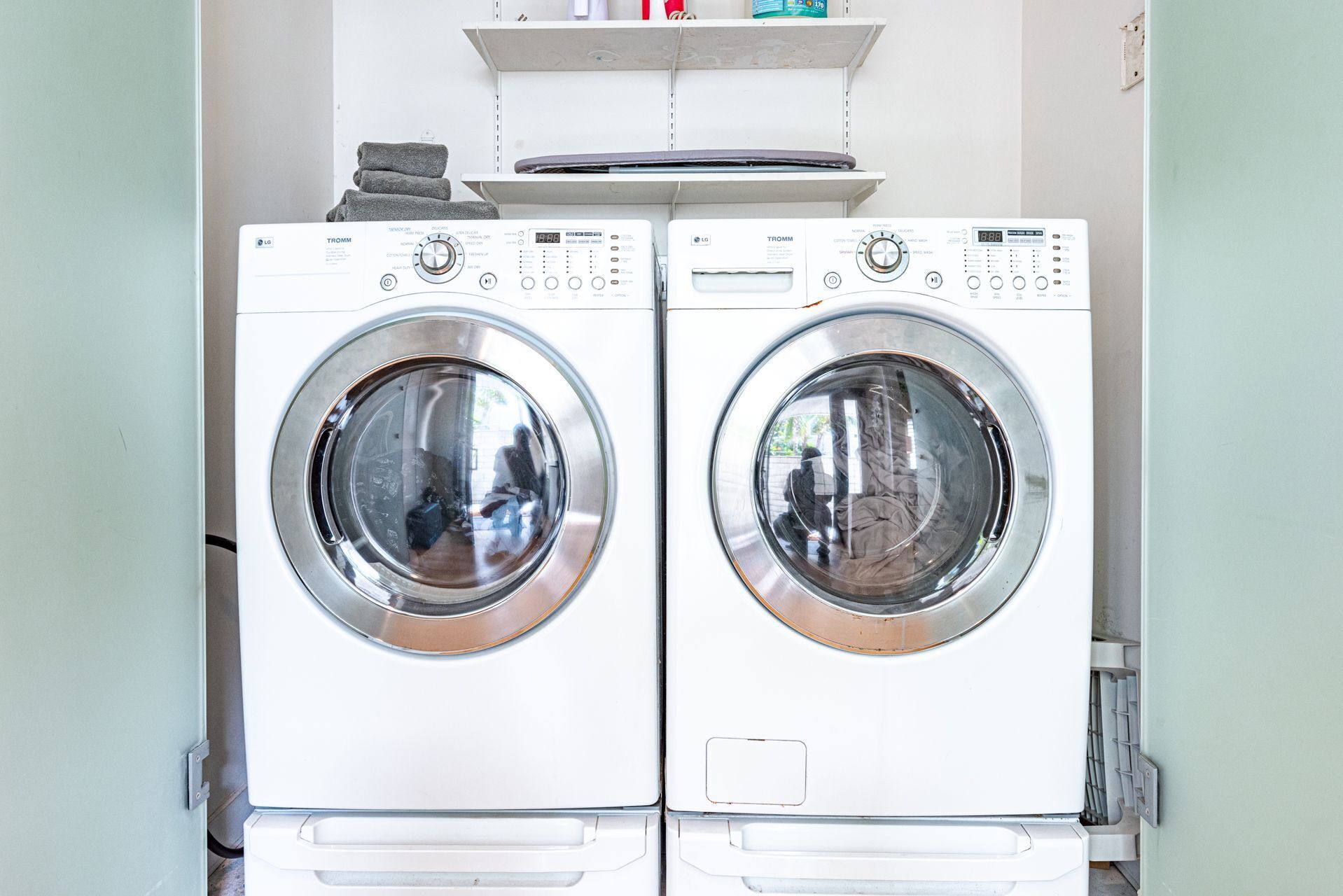 A pair of white front-loading washing machines with control panels, stacked on top of each other.