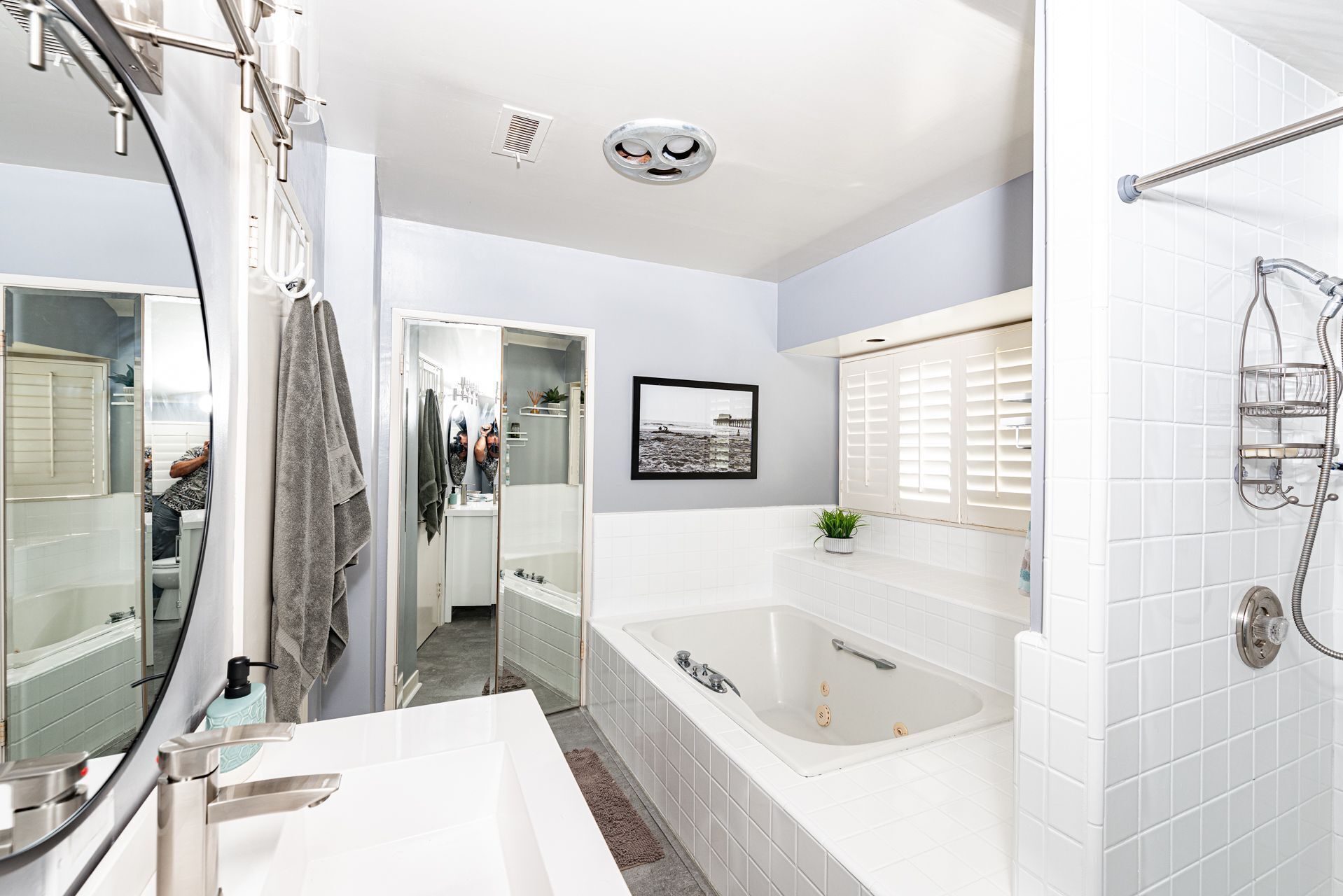 A modern bathroom with a large bathtub, a walk-in shower, a glass-enclosed shower area, and a mirror with a towel rack.