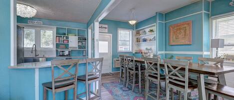 Una cocina con microondas, lavamanos y un cartel que dice 'BEACH HOUSE'.