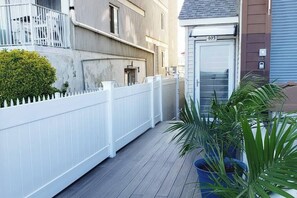 A residential building with a white fence, a door labeled '405', and a potted plant. - Modern Beachfront Suite 306 (Ocean City)