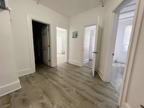 A spacious room with hardwood flooring, white walls, and multiple doorways leading to other rooms. - Modern Beachfront Suite 306 (Ocean City)