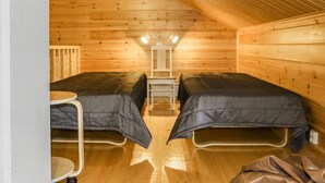 Una habitación pequeña y acogedora con dos camas, una mesa y una silla.
