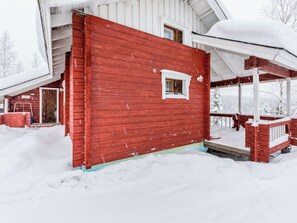 Une maison en bois rouge avec un porche et une fenêtre.