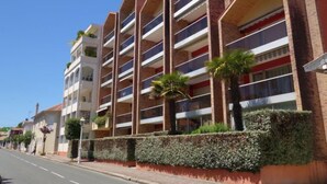 A multi-story building with a modern architectural design, featuring balconies and a brick facade. - Plein Soleil by Interhome (Arcachon)