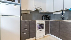 Eine moderne Küche mit weißen Schränken, einem eingebauten Backofen und einer Mikrowelle.