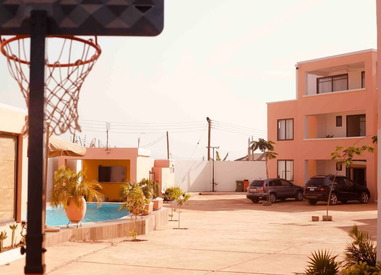 Un quartier résidentiel doté d’un terrain de basketball, d’une piscine et d’immeubles à deux étages.