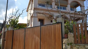 Een gebouw met twee verdiepingen, een balkon en een houten poort.
